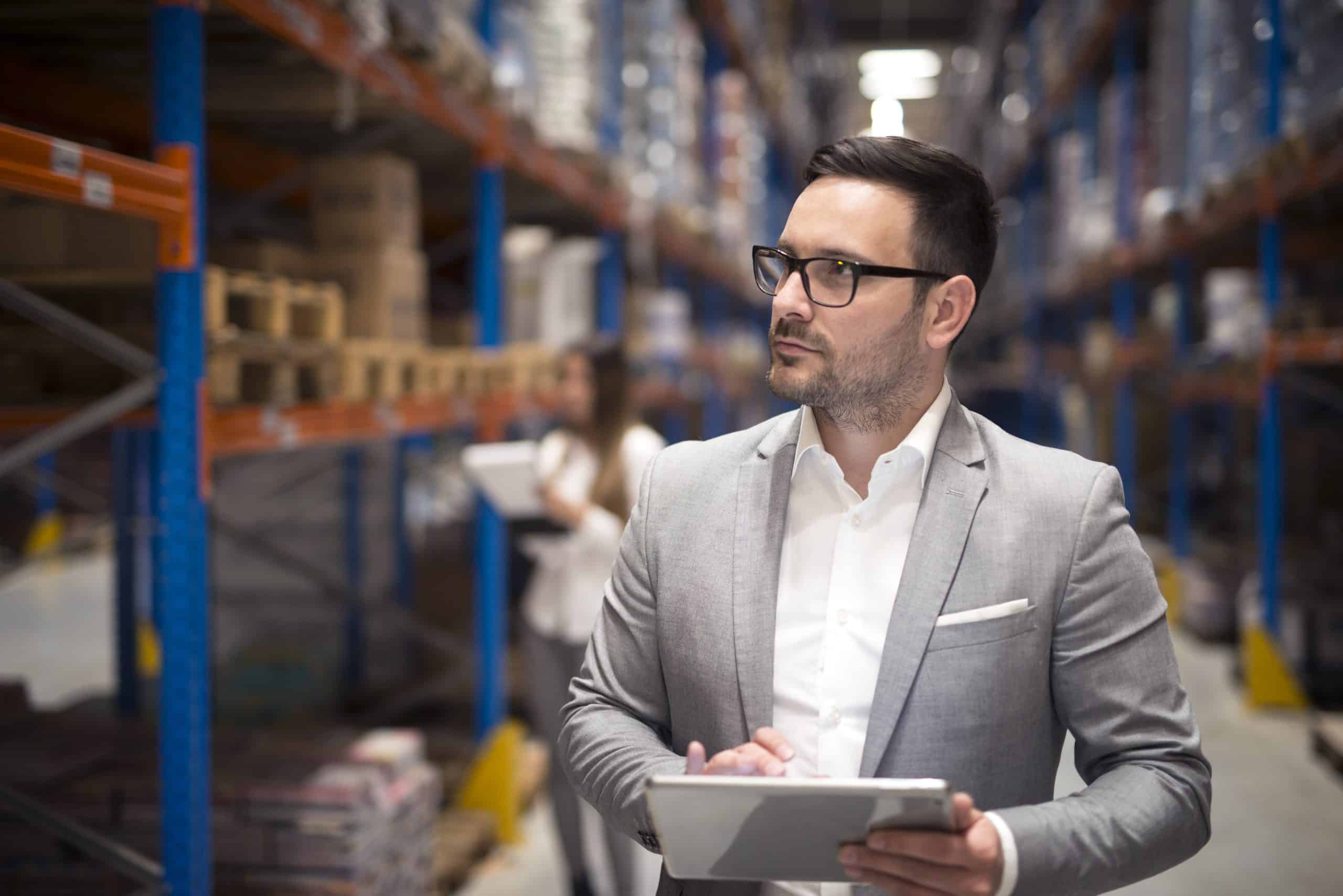 Gestor inspeciona o local com um tablet em mãos, representando a atenção necessária na contratação de uma empresa de segurança para condomínios e empreendimentos.