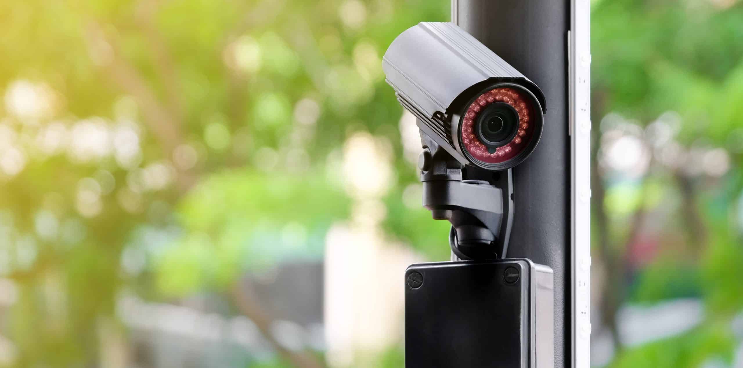 Câmera de segurança moderna instalada em área externa para monitoramento 24 horas.